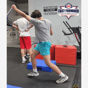 Man performing a stretching exercise in a gym.