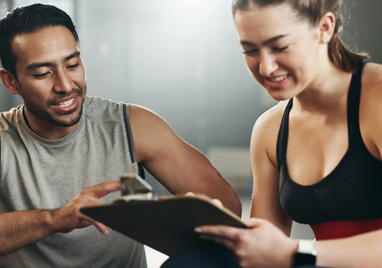 Two people reviewing a clipboard at gym.