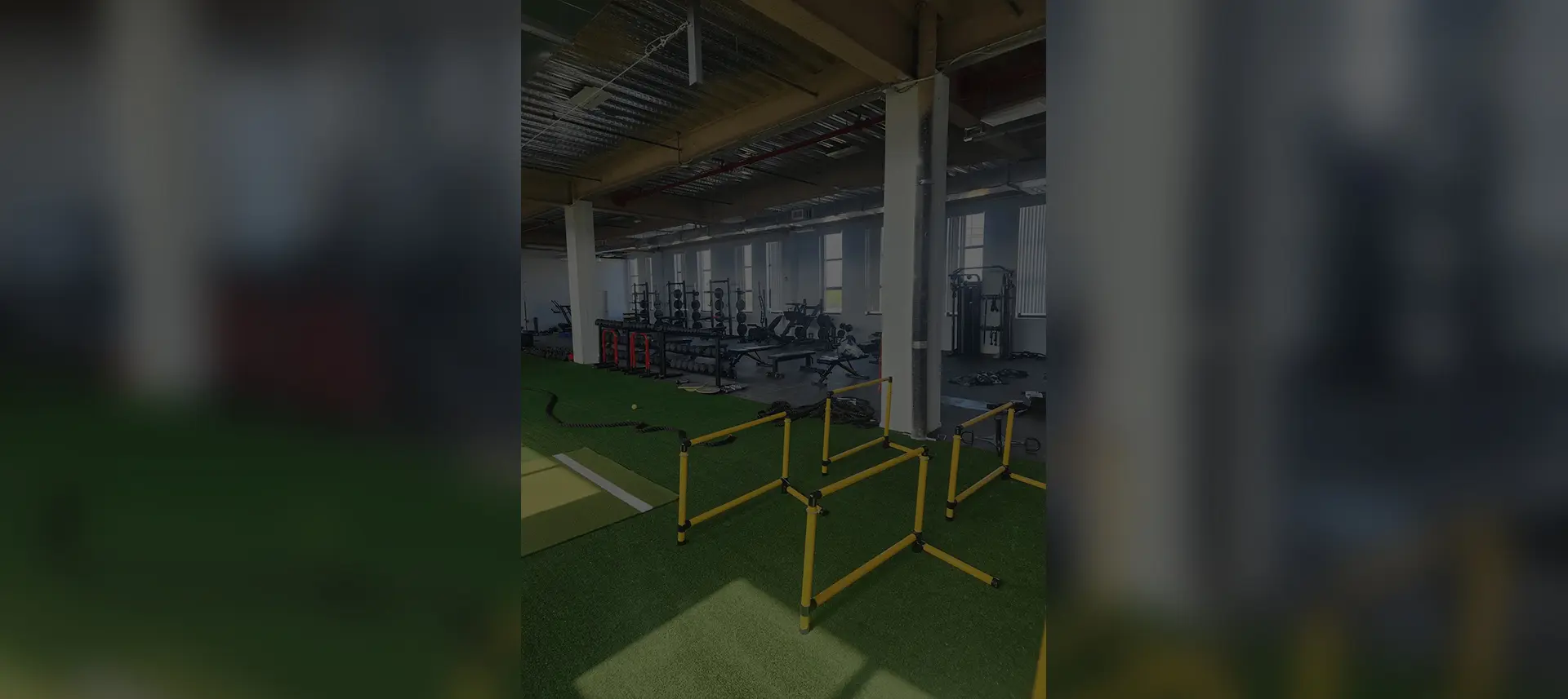 Indoor gym area with hurdles and weightlifting equipment.