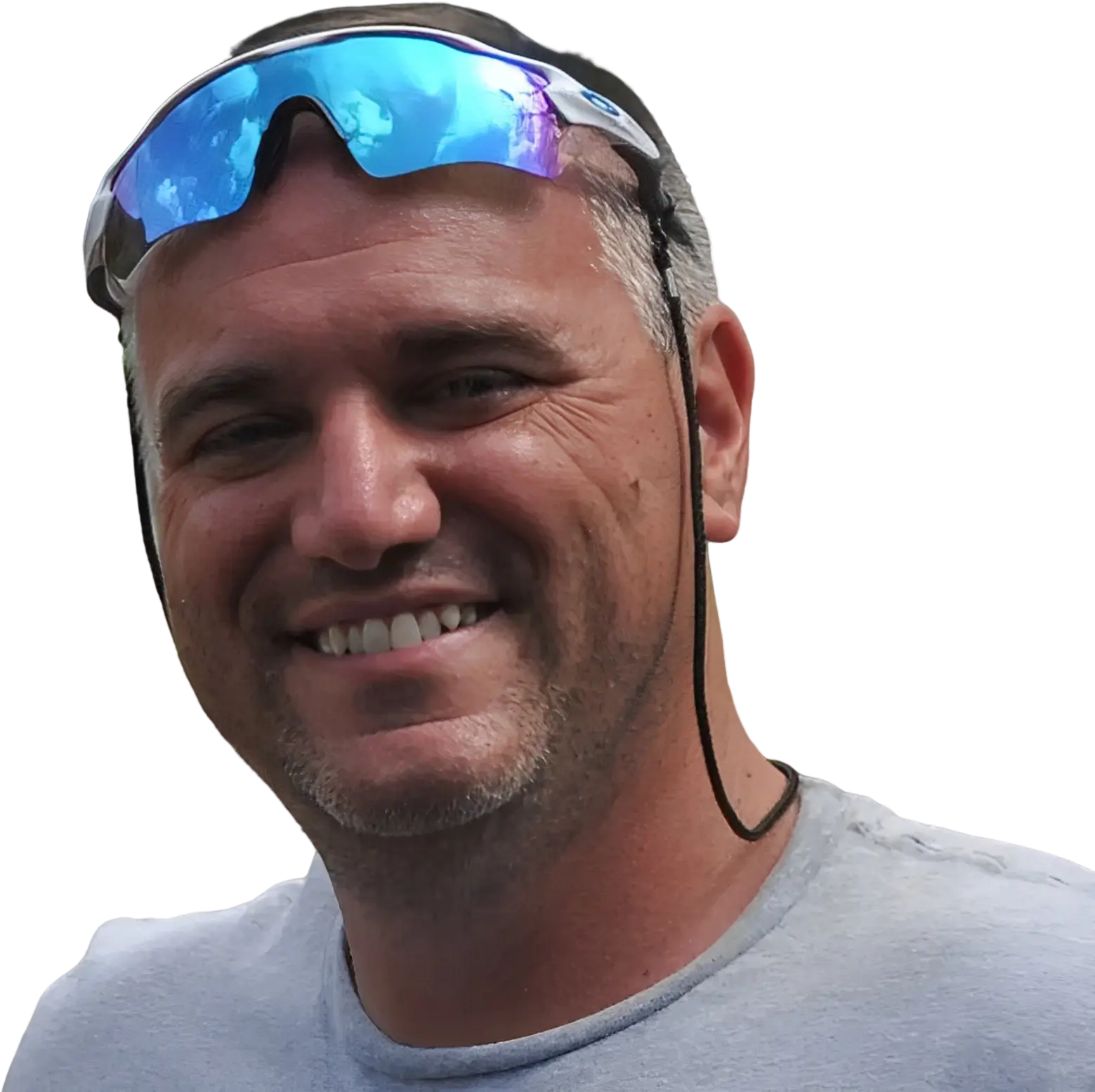 Smiling man wearing sunglasses on his head.